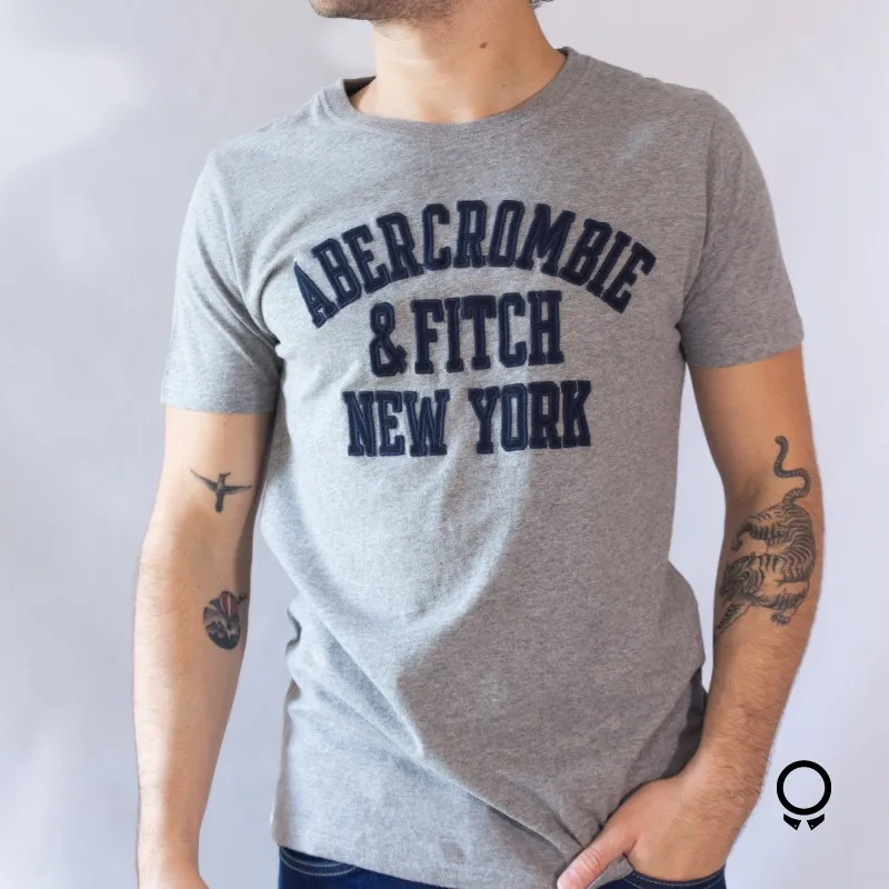 REMERA ABERCROMBIE CUELLO REDONDO GRIS ESTAMPA AZUL